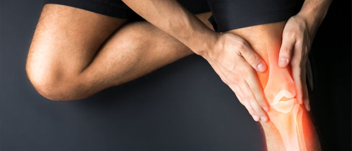 man holding knee and experiencing joint pain