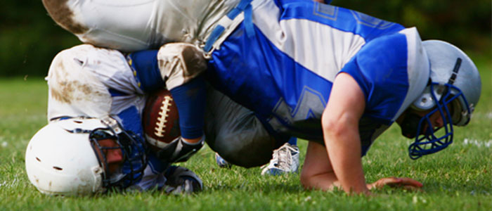 a photo of a kid being tackled in football